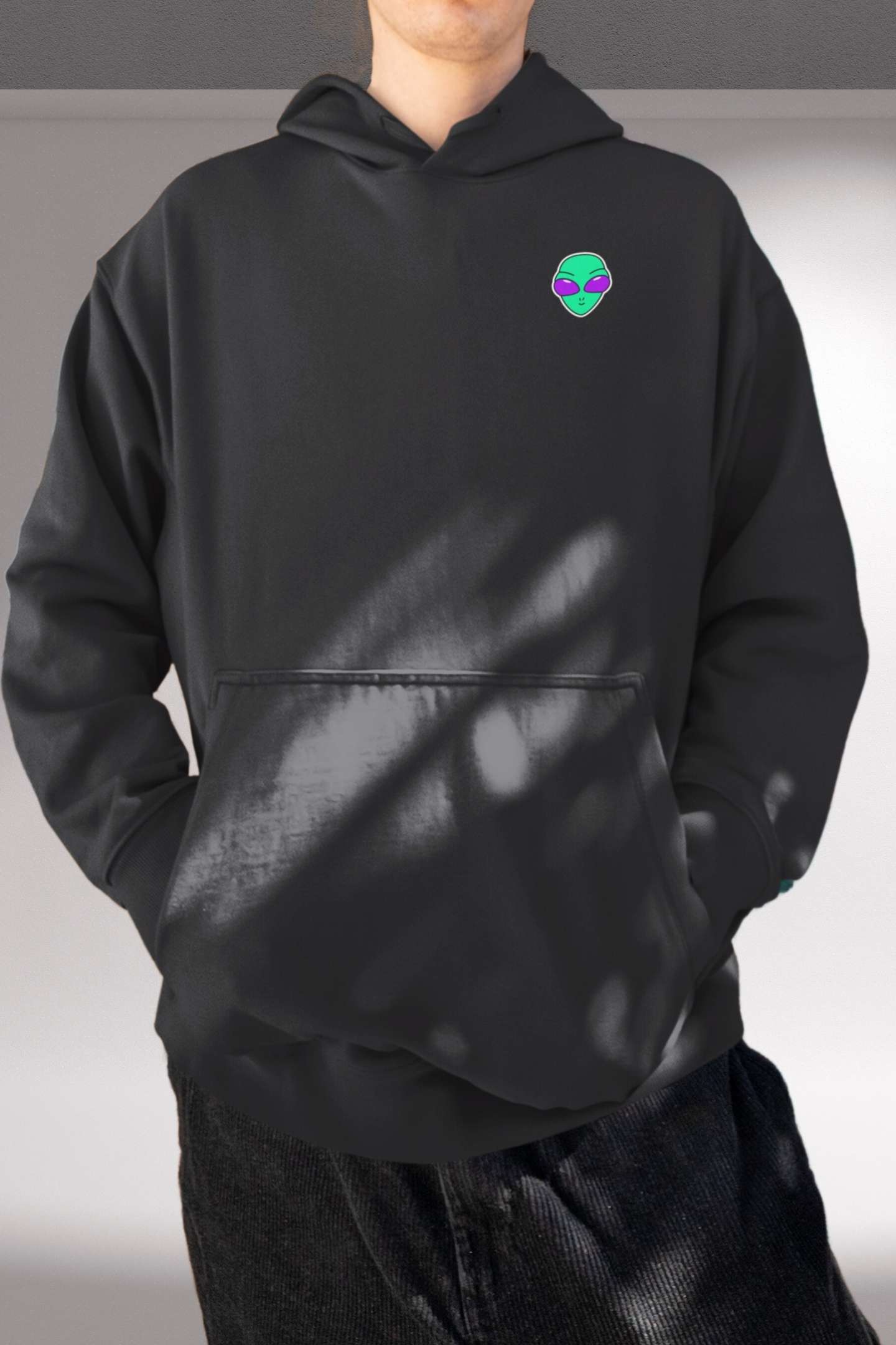 Alienhead Hoodie in black, front view worn by male model showcasing bold alien graphic and relaxed fit